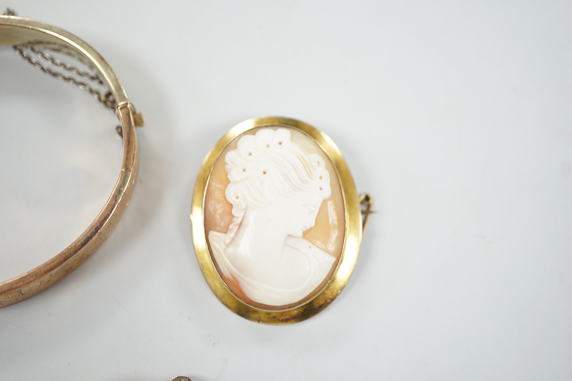 A 9ct mounted oval cameo shell brooch, 41mm, a 9ct gold bangle and a 9ct knot brooch